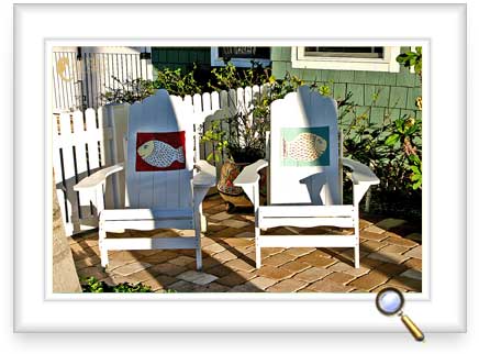 Painted adirondack chairs on a porch.