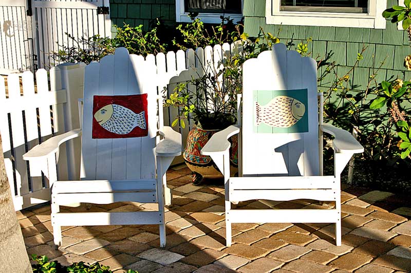 Painted adirondack chairs on a porch.